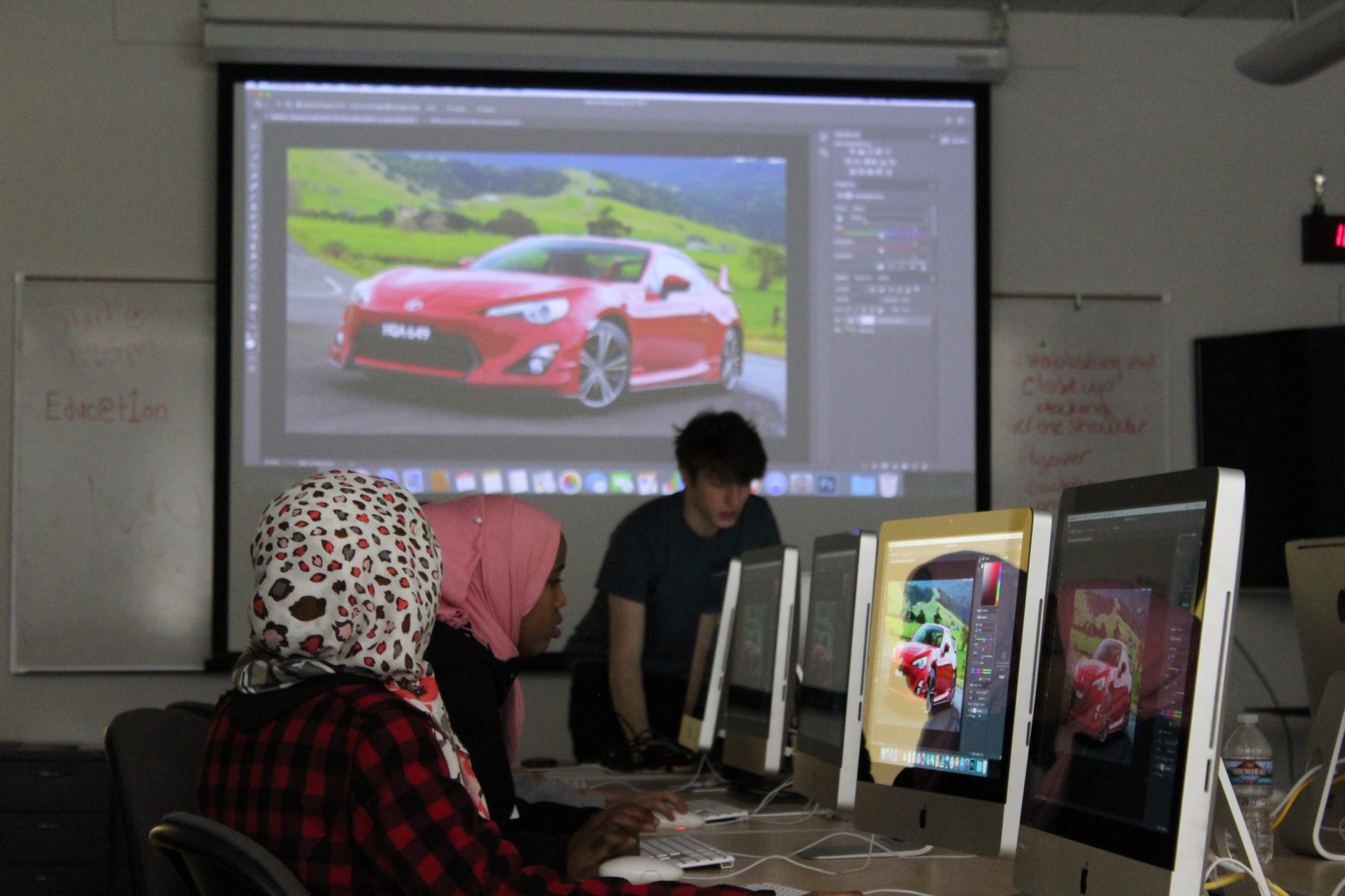 Students in a classroom working on a Photoshop tutorial