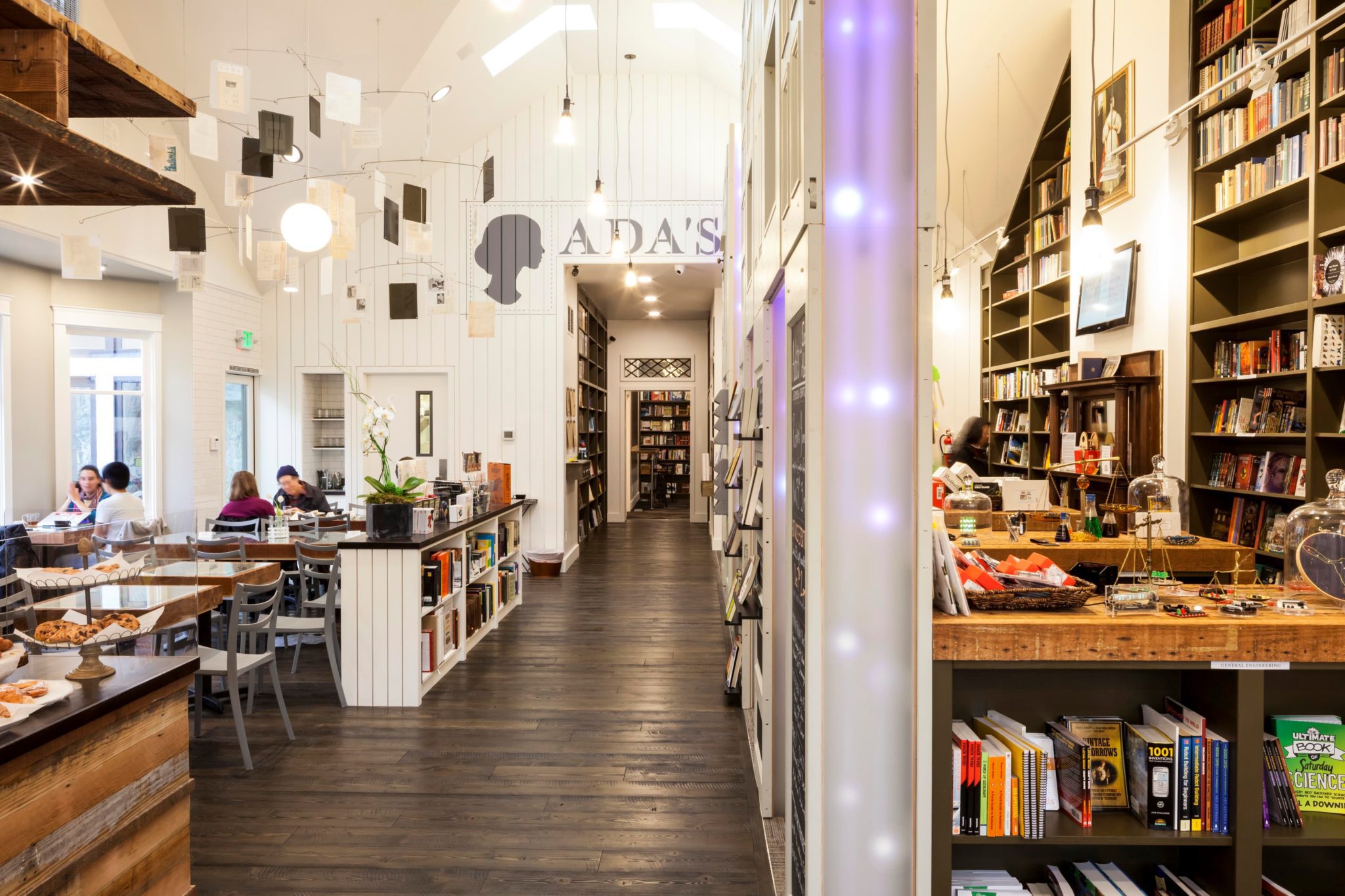A view of Ada's bookstore, with shelves on the right and a customer seating area to the left.